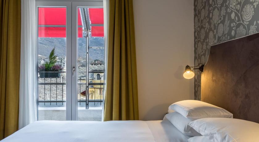 a bedroom with a bed and a window, Duca D'Aosta Hotel in Aosta