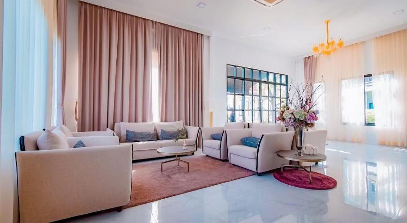 a living room filled with furniture and a large window, Phuengluang Riverside Hotel in Chanthaburi