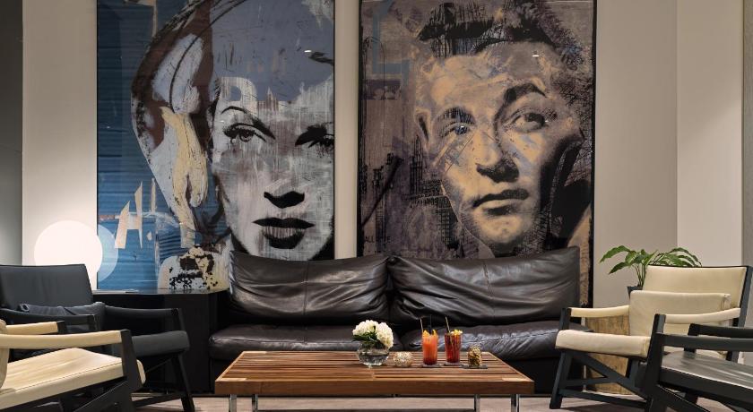 a living room filled with furniture and a painting on the wall, H10 Berlin Ku'damm Hotel in Berlin