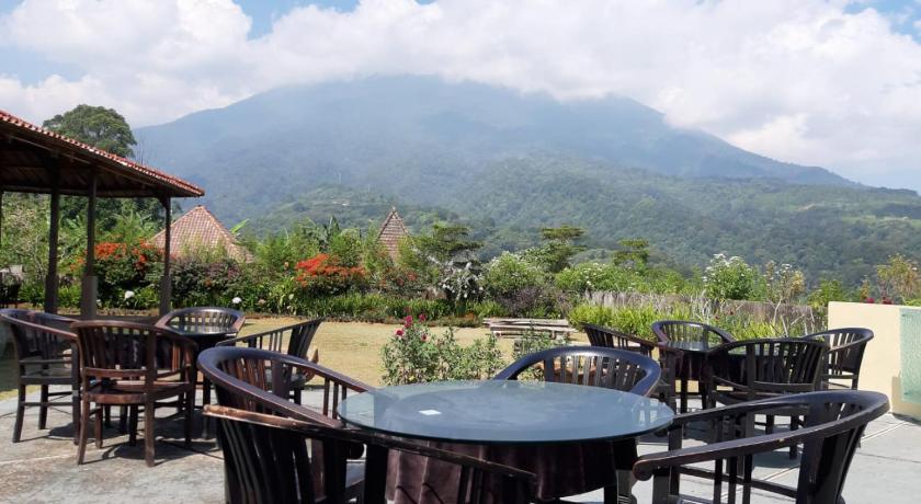 a dining room table with chairs and a patio, De Summit of Eaden Villa in Puncak