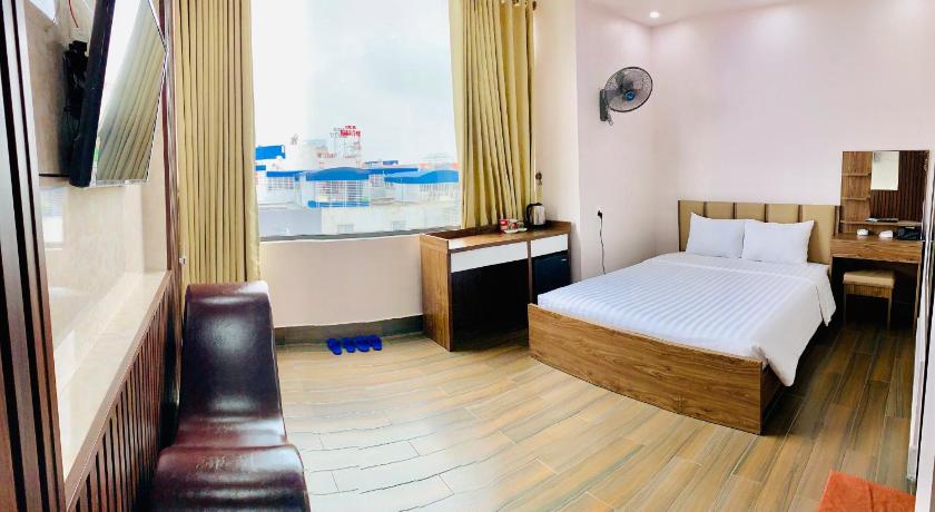 a bedroom with a bed, chair, and a television, MV HOTEL in Haiphong
