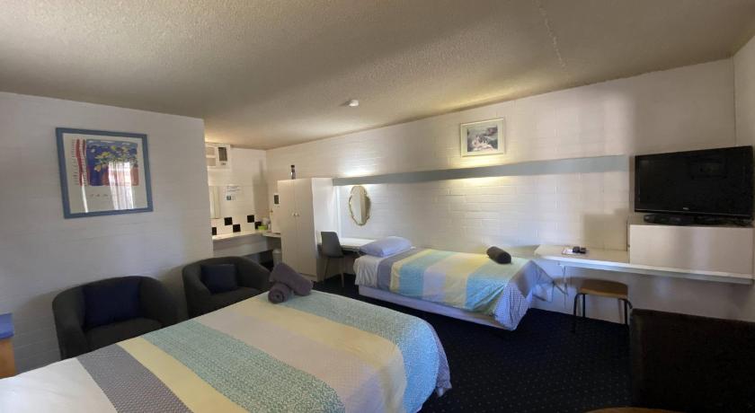 a hotel room with two beds and a television, Capri Motel in Balranald