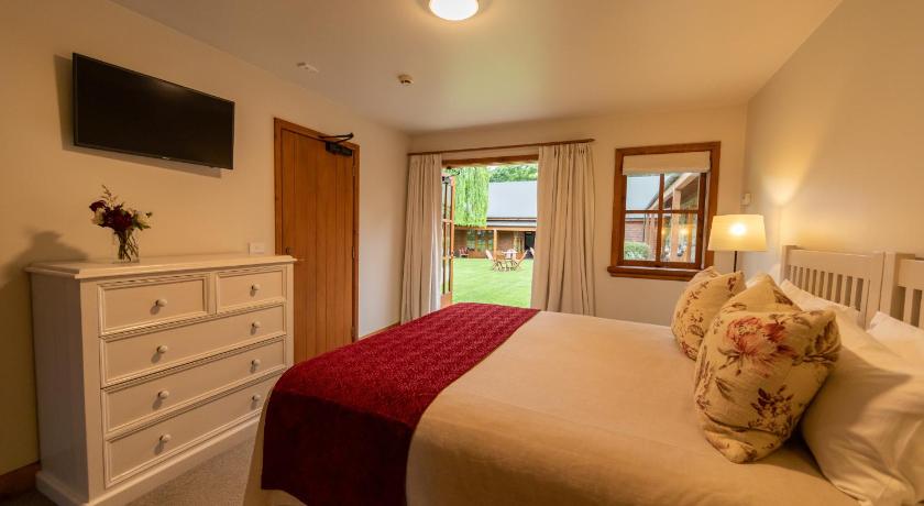 a bedroom with a bed and a dresser, Wanaka Homestead Lodge & Cottages in Wanaka