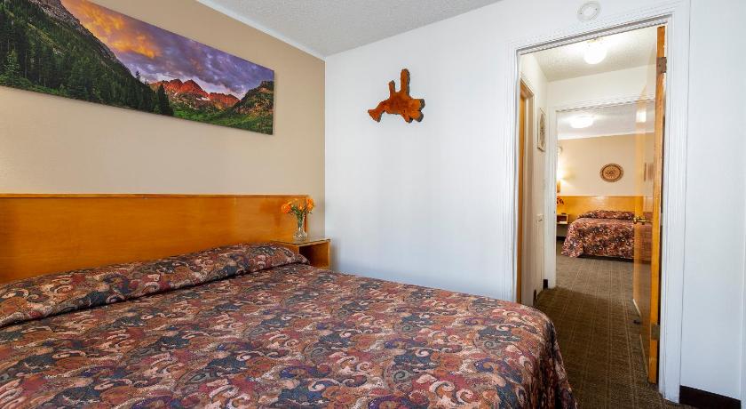 a hotel room with a bed and a television, Starlight Lodge in Glenwood Springs (CO)