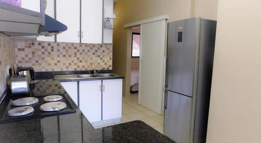 a kitchen with a refrigerator, stove, sink and microwave, Cabanas Del Mar in Durban