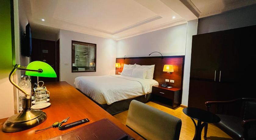 a hotel room with a bed, desk, lamp and a television, The Vancouver Hotel Ninh Binh in Ninh Bình