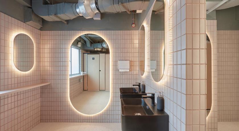 a bathroom with a sink and a mirror, KINN Capsule Hotel in Singapore