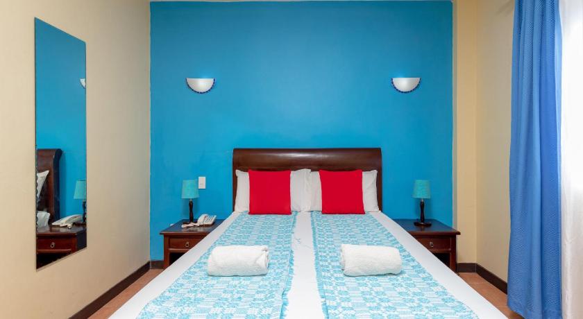 two beds in a small room with blue walls, OveMar Resort Hotel in Ilocos Sur