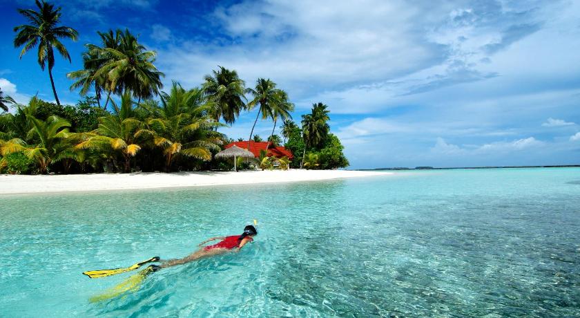 a person in the water with a surfboard, Kurumba Maldives in Maldive Islands
