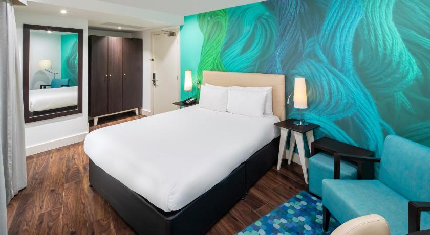 a hotel room with a large bed and a painting on the wall, Hotel Indigo Liverpool in Liverpool