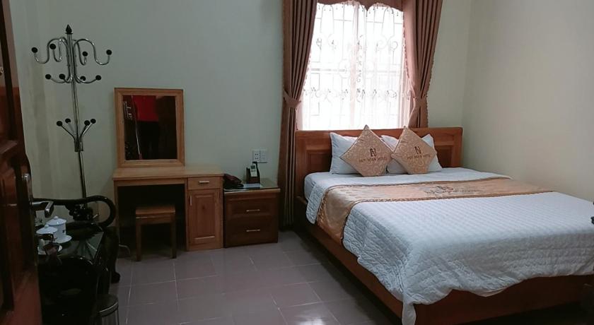 a bedroom with a bed and a dresser, Huy Hoan Hotel in Ha Giang