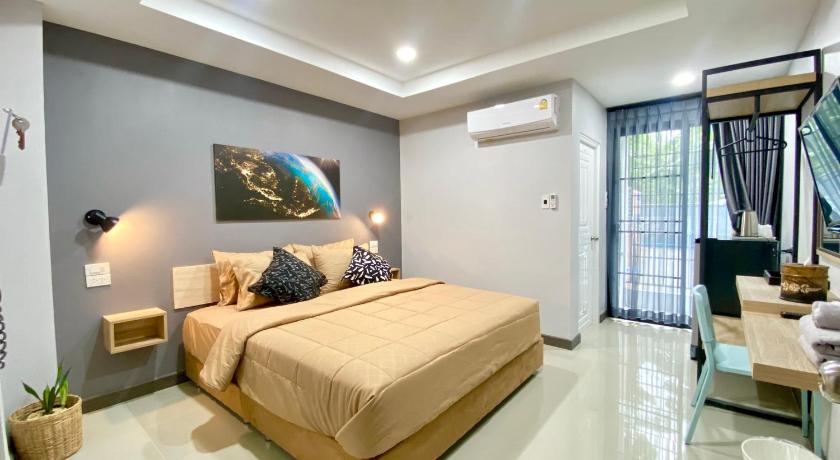 a bedroom with a large bed and a large window, The Hub Hotel Surin (SHA Plus+) in Surin