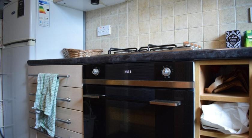 a kitchen with a stove top oven and a sink, Cosy 1 Bed Flat In Homerton By Victoria Park in London