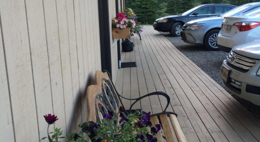a wooden bench with flowers on it near a dock, Denali Park Hotel in Healy (AK)