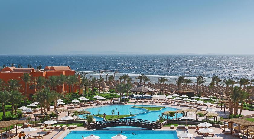 a beach with a large swimming pool and palm trees, Sharm Grand Plaza Resort - Families and Couples Only in Sharm El Sheikh
