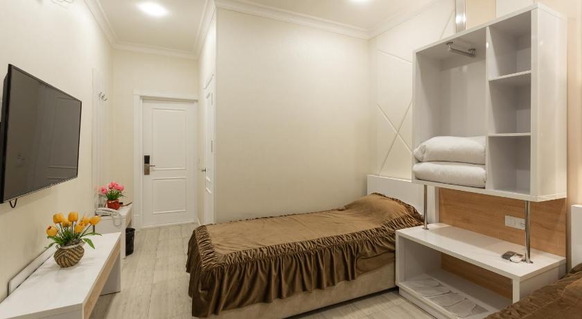 a bedroom with a bed and a dresser, Tantana Hotel in Fergana