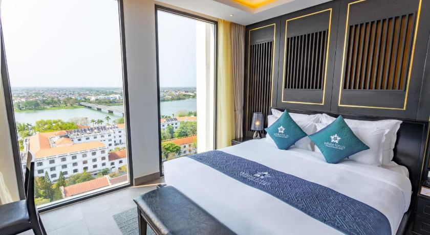 a hotel room with two beds and a large window, White Lotus Hue Hotel in Hue