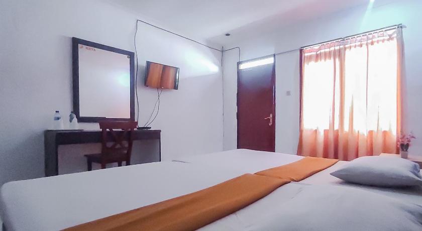a hotel room with a bed and a television, Burangrang Village in Puncak