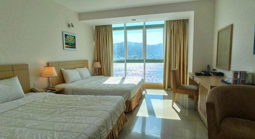 a hotel room with two beds and a window, River Hotel Ha Tien in Ha Tien (Kien Giang)