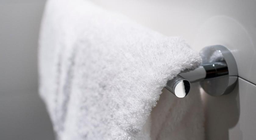 a white towel hanging from a white shower curtain, Motel One Paris-Porte Dorée in Paris