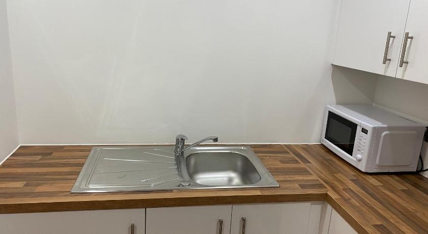 a kitchen with a sink and a microwave, 1 bedroom lovely apartment in Salford quays free street parking subject to availability in Manchester