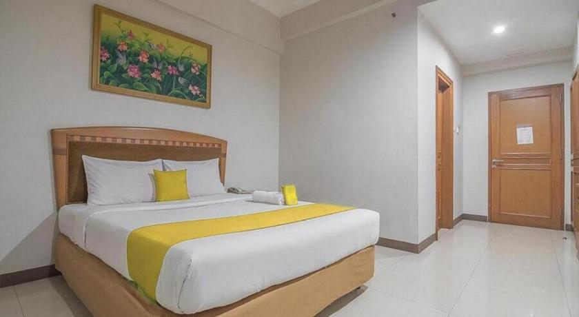a hotel room with a bed and a desk, Hotel Yehezkiel Surapati in Bandung