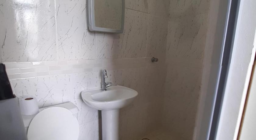 a bathroom with a toilet a sink and a mirror, Balcony Hostel Hotel in São Paulo