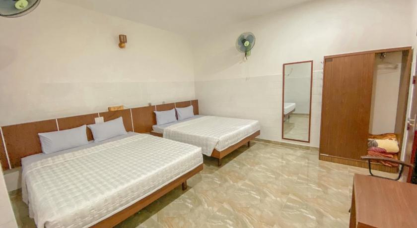a hotel room with two beds and a desk, Khach san Ngoc Bich in Phan Rang – Tháp Chàm (Ninh Thuận)