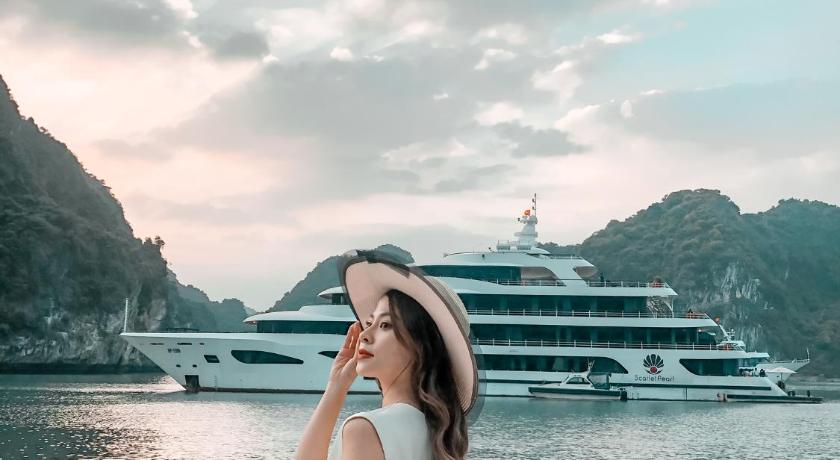 a woman standing in front of a boat in the water, Scarlet Pearl Cruises in Hạ Long