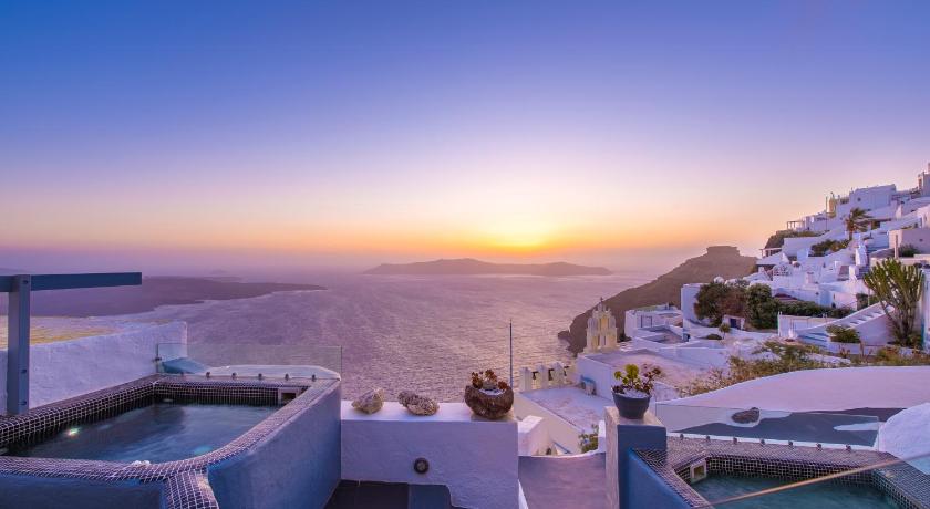 a view from a boat of a beach with a view of the ocean, Exclusive Suites in Santorini