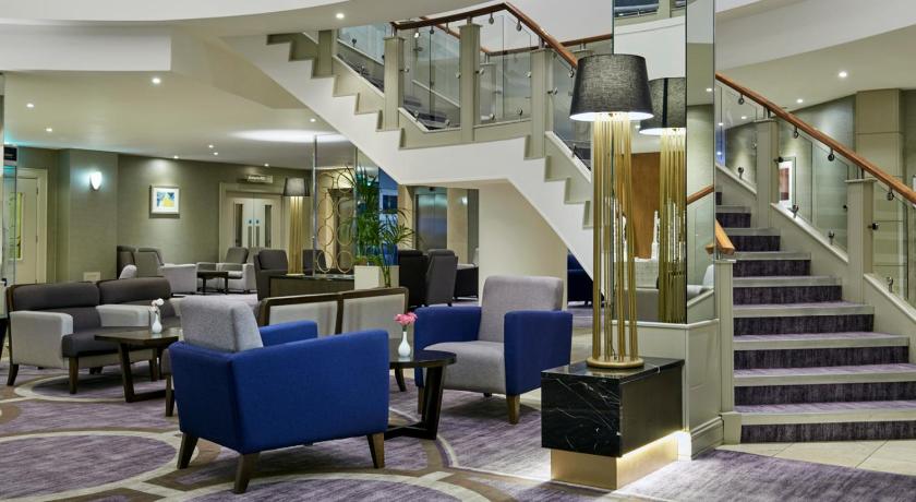 a living room filled with furniture and a stairway, Crowne Plaza - Belfast in Belfast