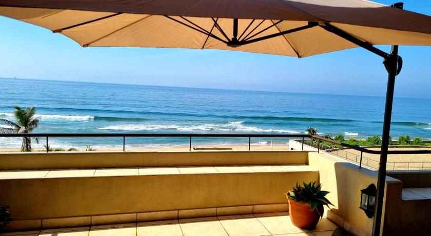 a beach with umbrellas and a balcony overlooking the ocean, Bonna Vista in Durban