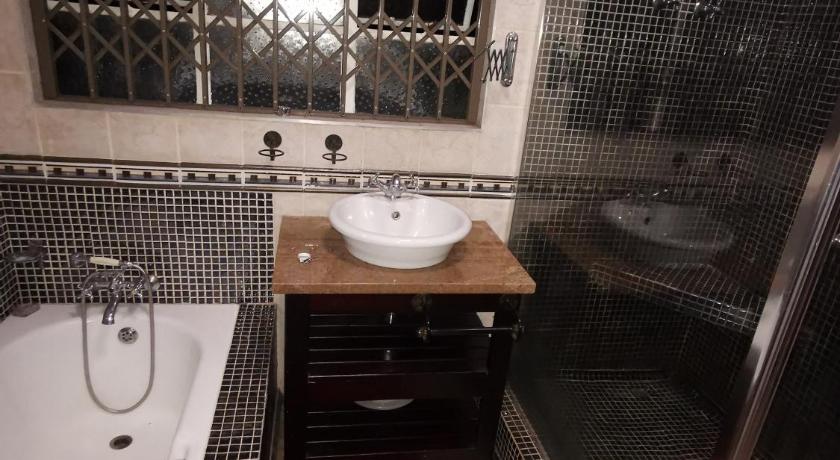 a bathroom with a sink, toilet, and bathtub, 497 on west ave guest house in Johannesburg