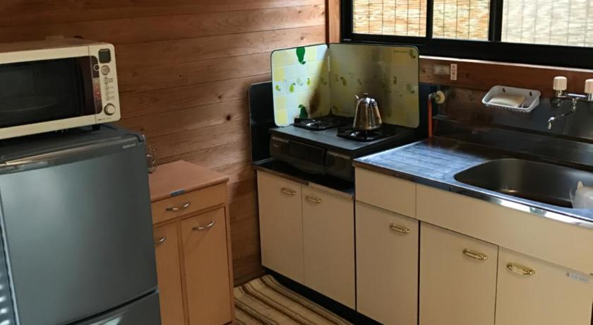 a kitchen with a stove top oven and a refrigerator, Wa no Cottage Sen-no-ie in Yakushima