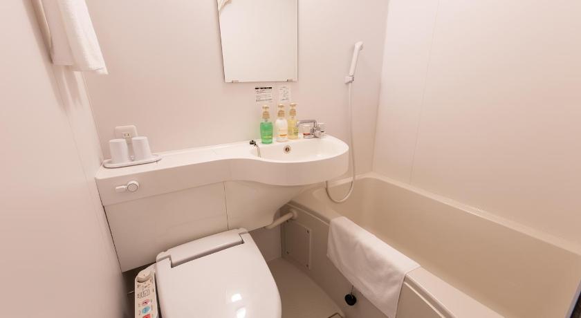 a white toilet sitting next to a sink in a bathroom, Hotel Kansai in Osaka