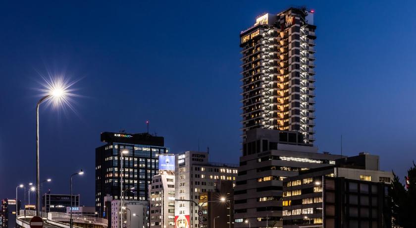 a city at night with tall buildings and traffic lights, APA Hotel Shinosaka eki Tower in Osaka