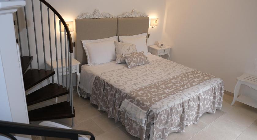 a large white bed sitting in a room next to a doorway, PLAZACARRISI HOTEL & SPA in Cellino San Marco