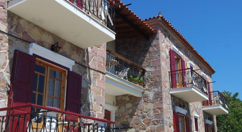 a large brick building with windows and a balcony, The Schoolmistress With The Golden Eyes, studios & rooms in Lesvos