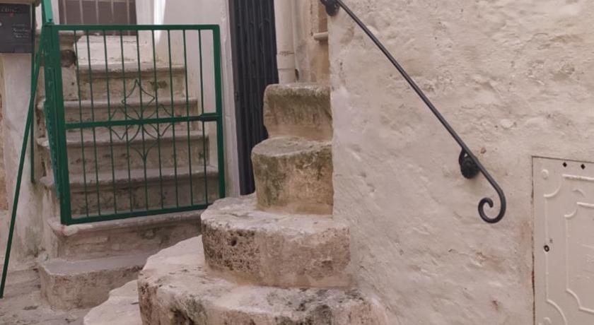 a stone wall with stairs leading up to a building, La Volta del Conte-Holiday Home Centro Storico in Cisternino