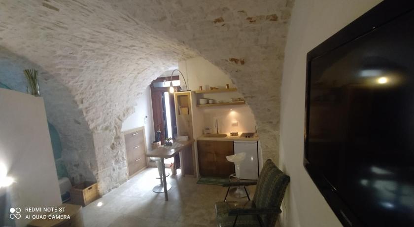 a room that has a table and a chair in it, La Volta del Conte-Holiday Home Centro Storico in Cisternino