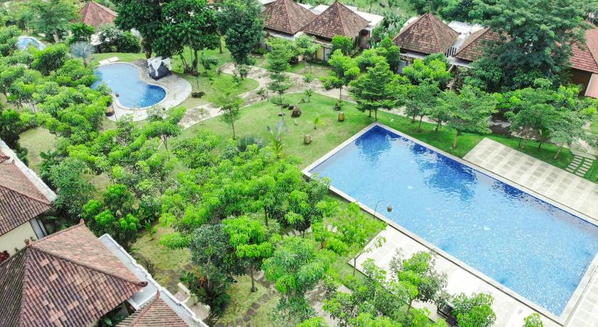a large pool of water surrounded by trees, Shanaya Resort Malang in Malang