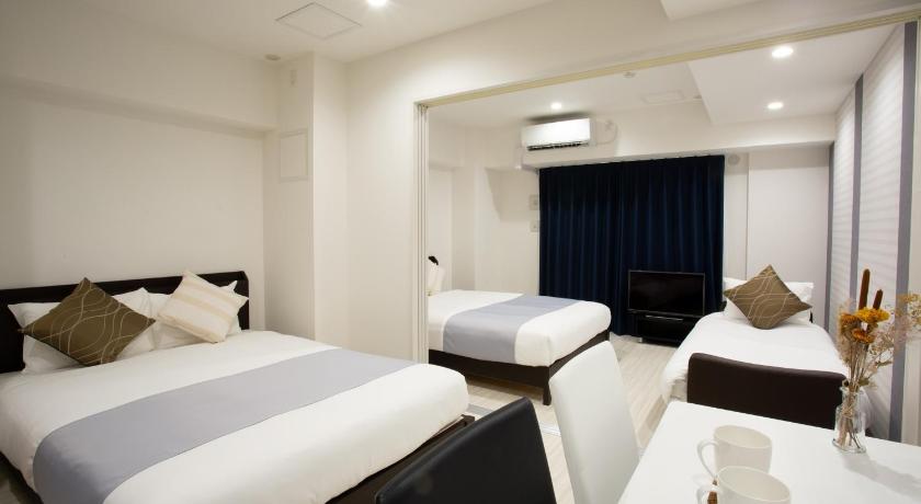 a hotel room with two beds and two lamps, Bon Condo Namba Nipponbashi in Osaka