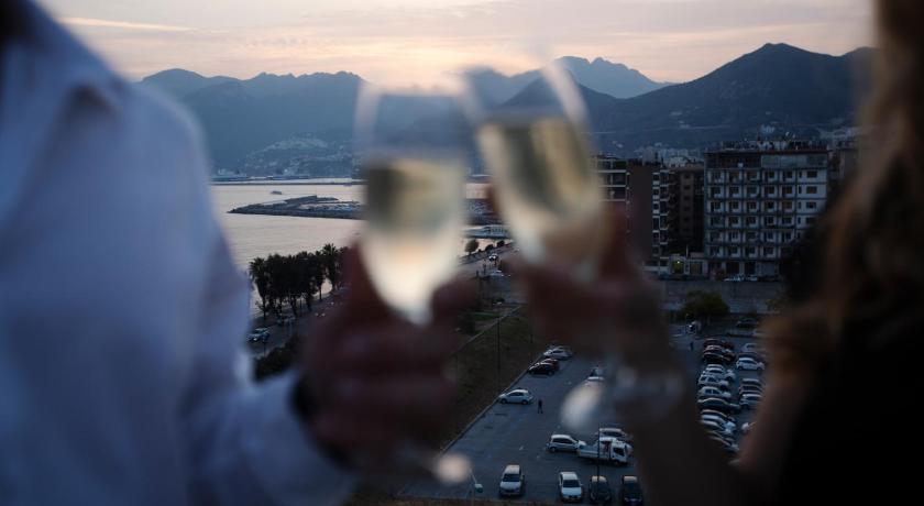 a woman holding a glass of wine in front of a group of people, Grand Hotel Salerno in Salerno