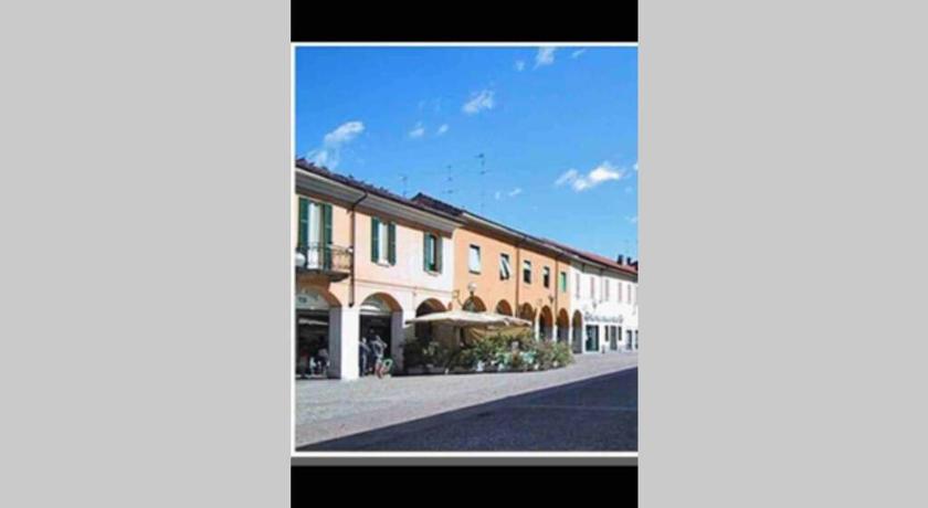 a street scene with a house and a building, Green Appartamenti i Portici nel centro storico in Melzo