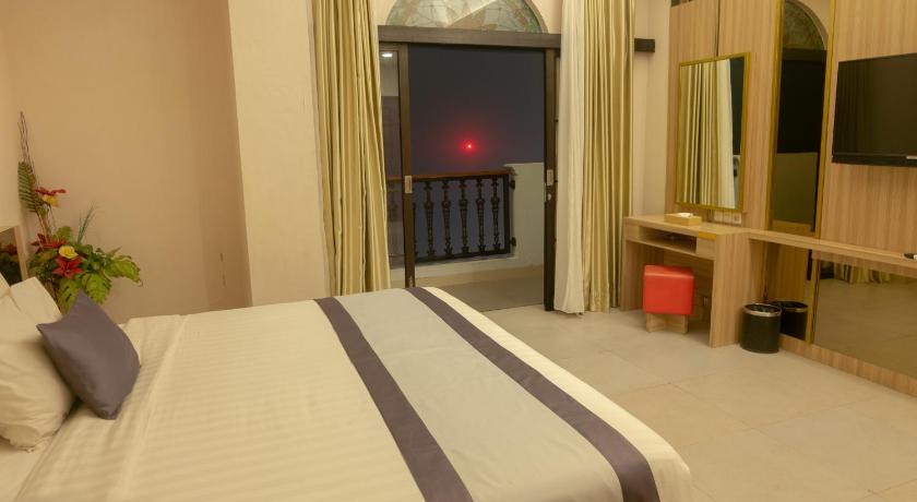 a hotel room with a bed and a tv, @K Hotel Kaliurang Yogyakarta in Yogyakarta