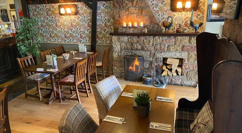 a dining room table with a fireplace, Old Aberlady Inn in Aberlady