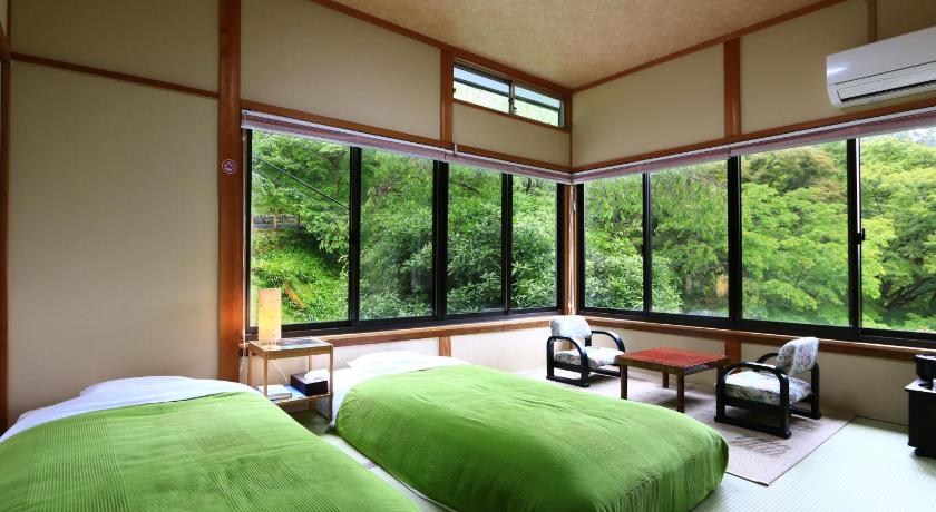 a bedroom with two beds and two windows, Miyoshino Sakuraan in Yoshino