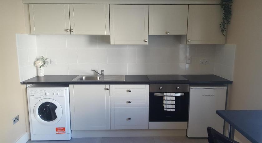a kitchen with white cabinets and white appliances, Shamrock Lodge Hotel in Athlone