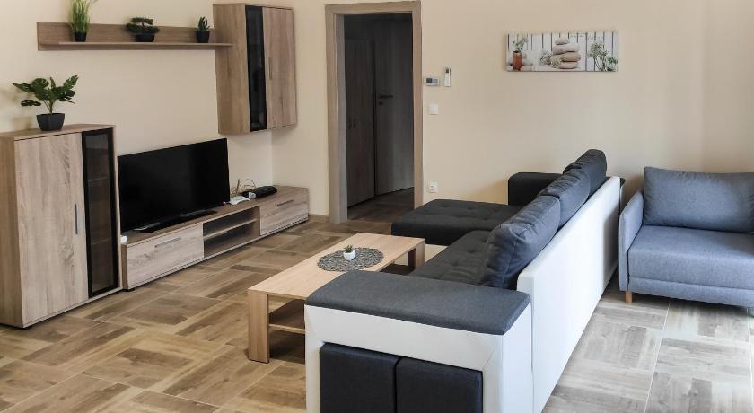 a living room filled with furniture and a tv, Trika Apartman in Sarvar