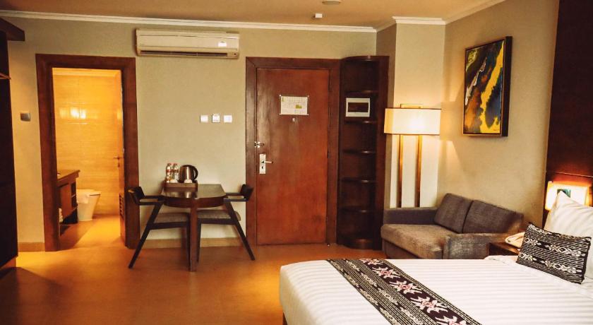 a living room filled with furniture and a large window, Sotis Hotel Kemang Jakarta in Jakarta